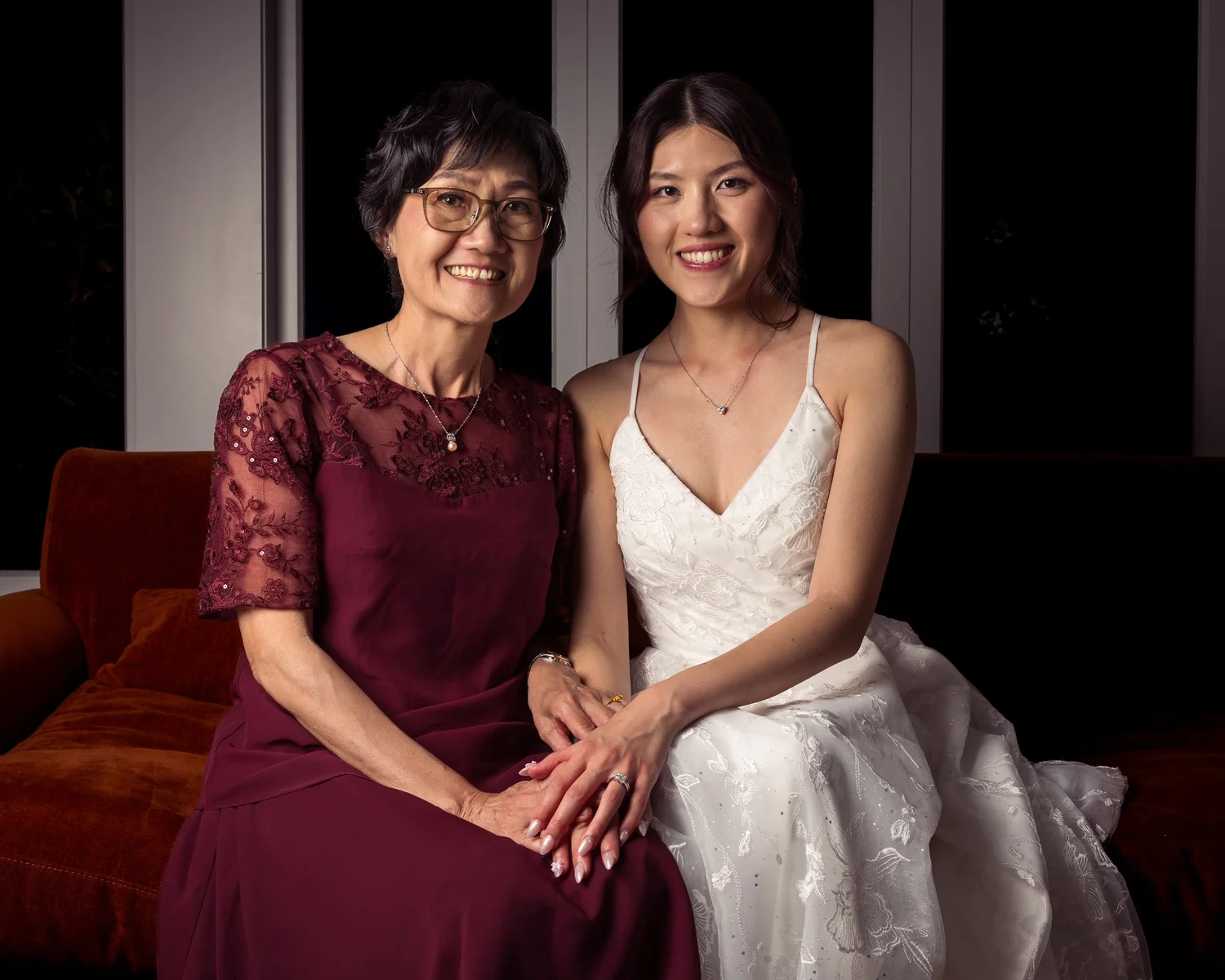 Cherry and a family member sit together on a red velvet sofa