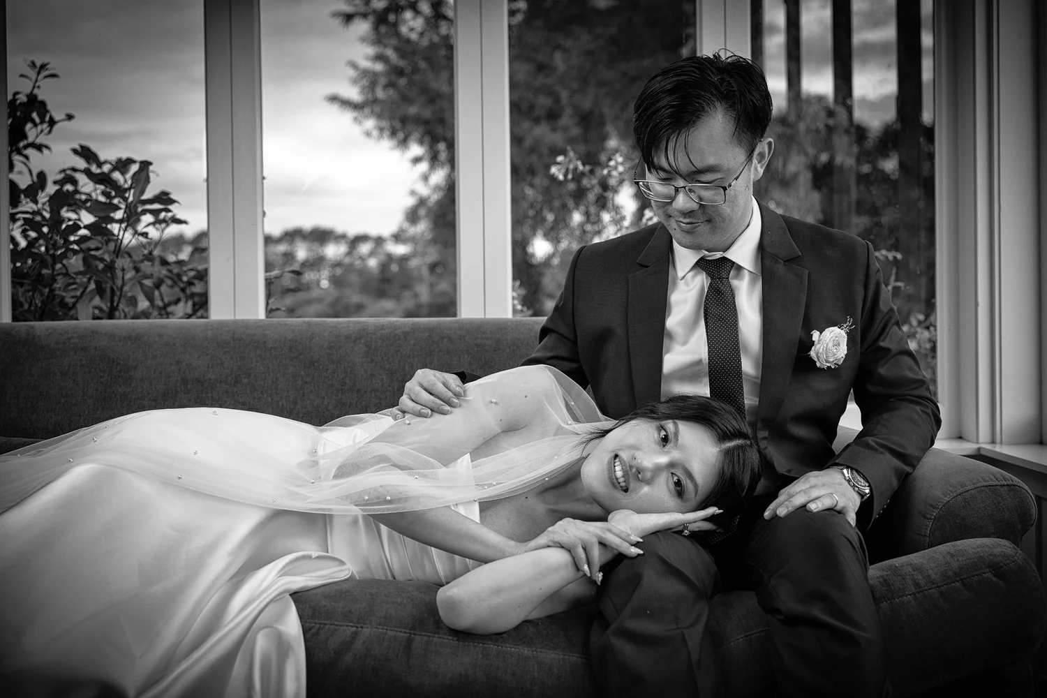 Black and white photo of Cherry lying on a sofa beside Chi