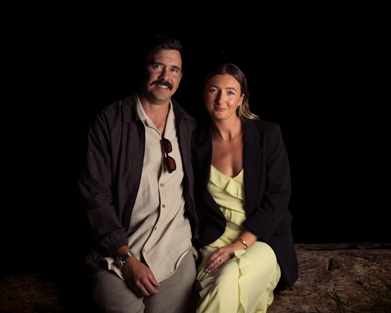 Two guests pose for a portrait at night