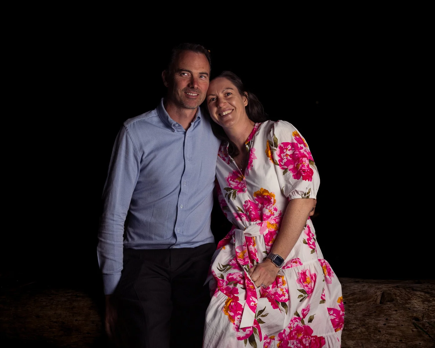 Two guests smile for a portrait at night