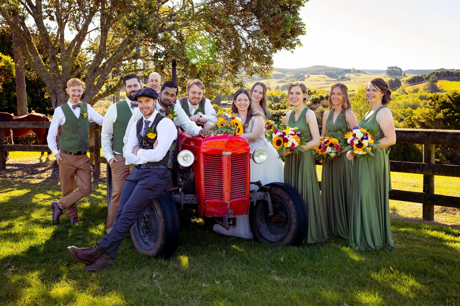 The bridal party gathered around a red tractor