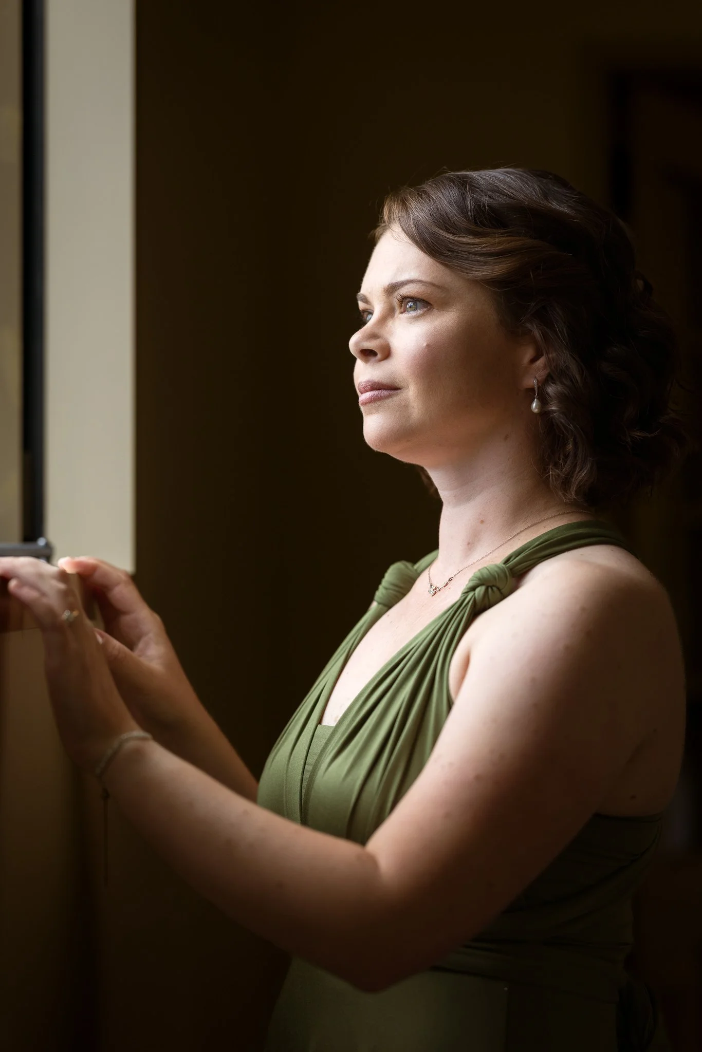 A bridesmaid in green in soft window light