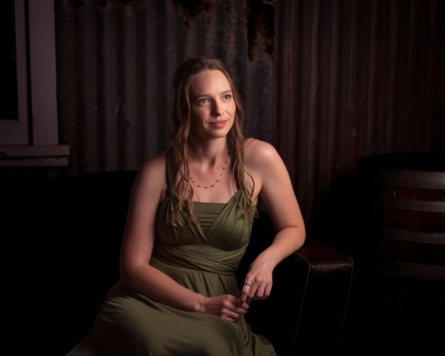 A guest in green seated for an evening portrait