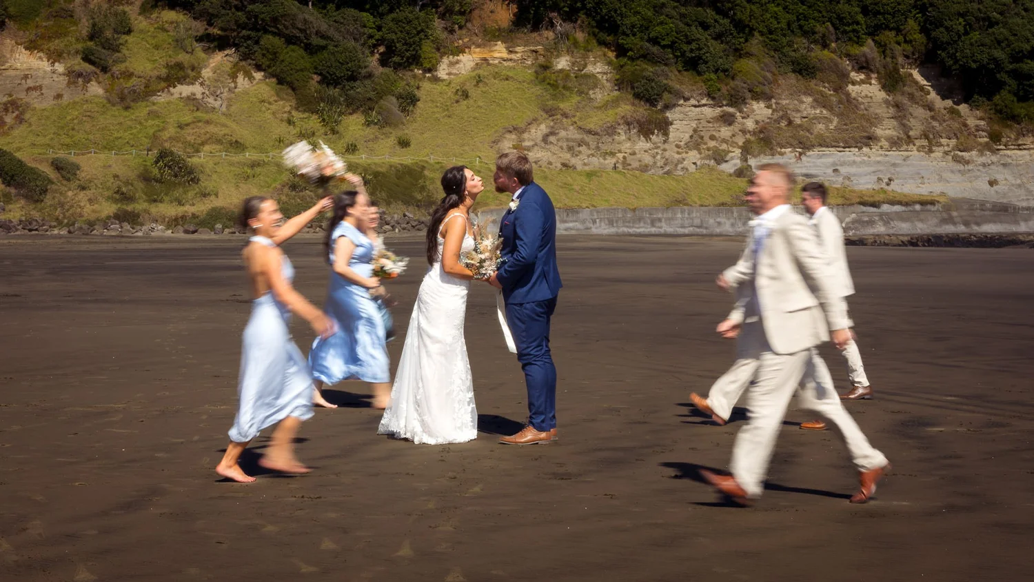 Tay and Jesse with their bridal party on a black sand beach