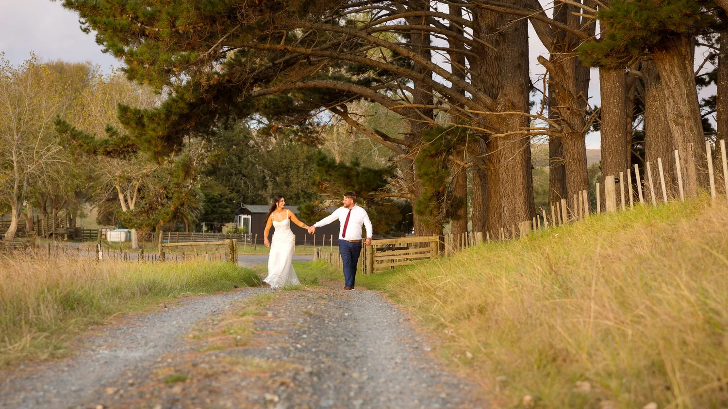 Tay and Jesse walk hand in hand down a gravel road