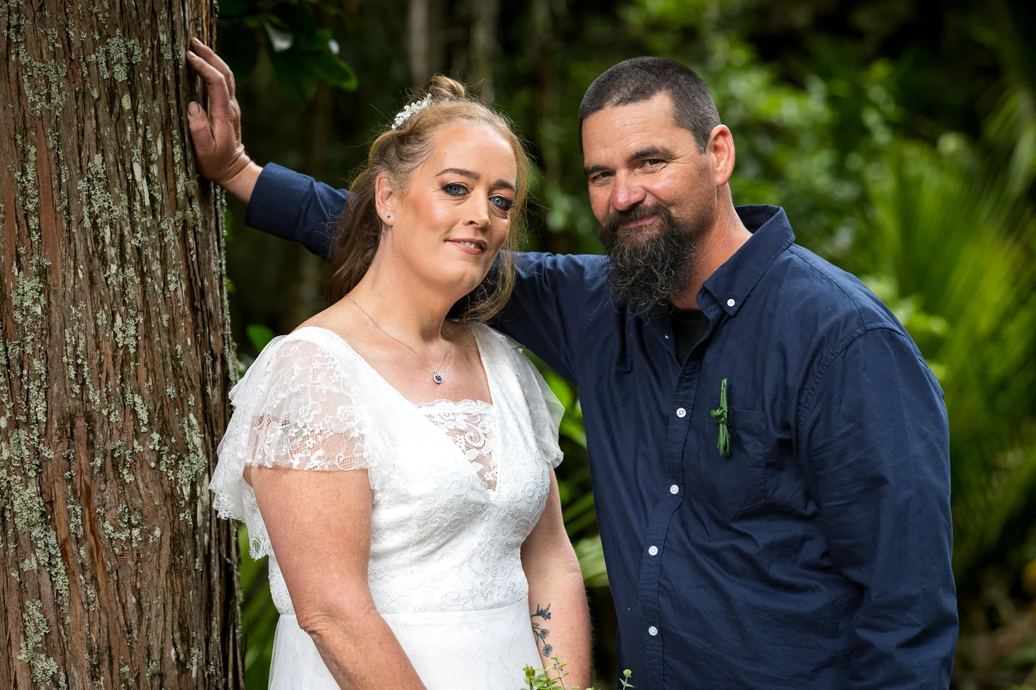Julia and Alistair lean against a tree trunk