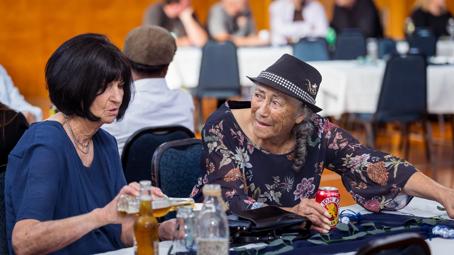 Guests laugh together at their table in the local hall