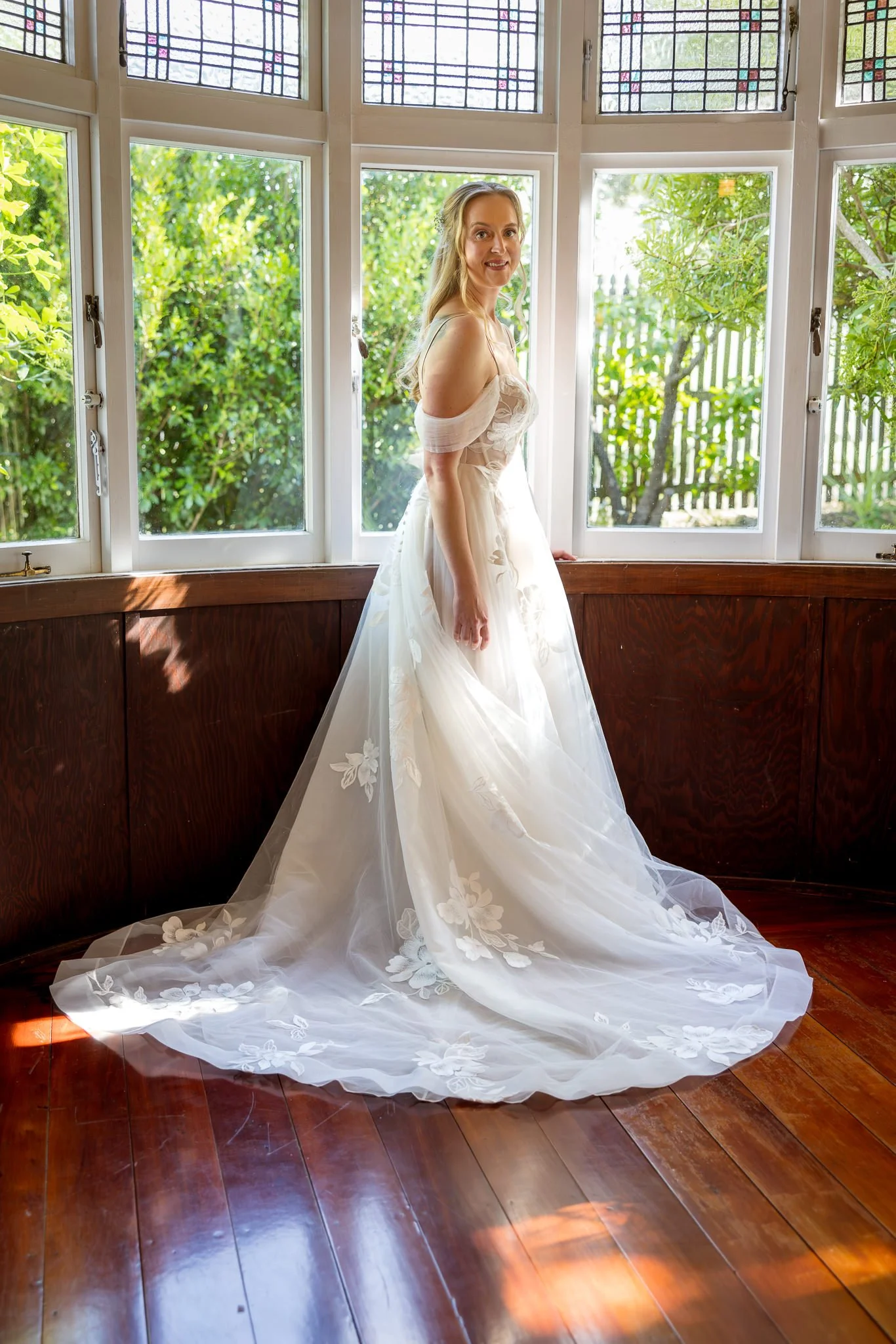 Kayla in her gown in a sunlit bay window