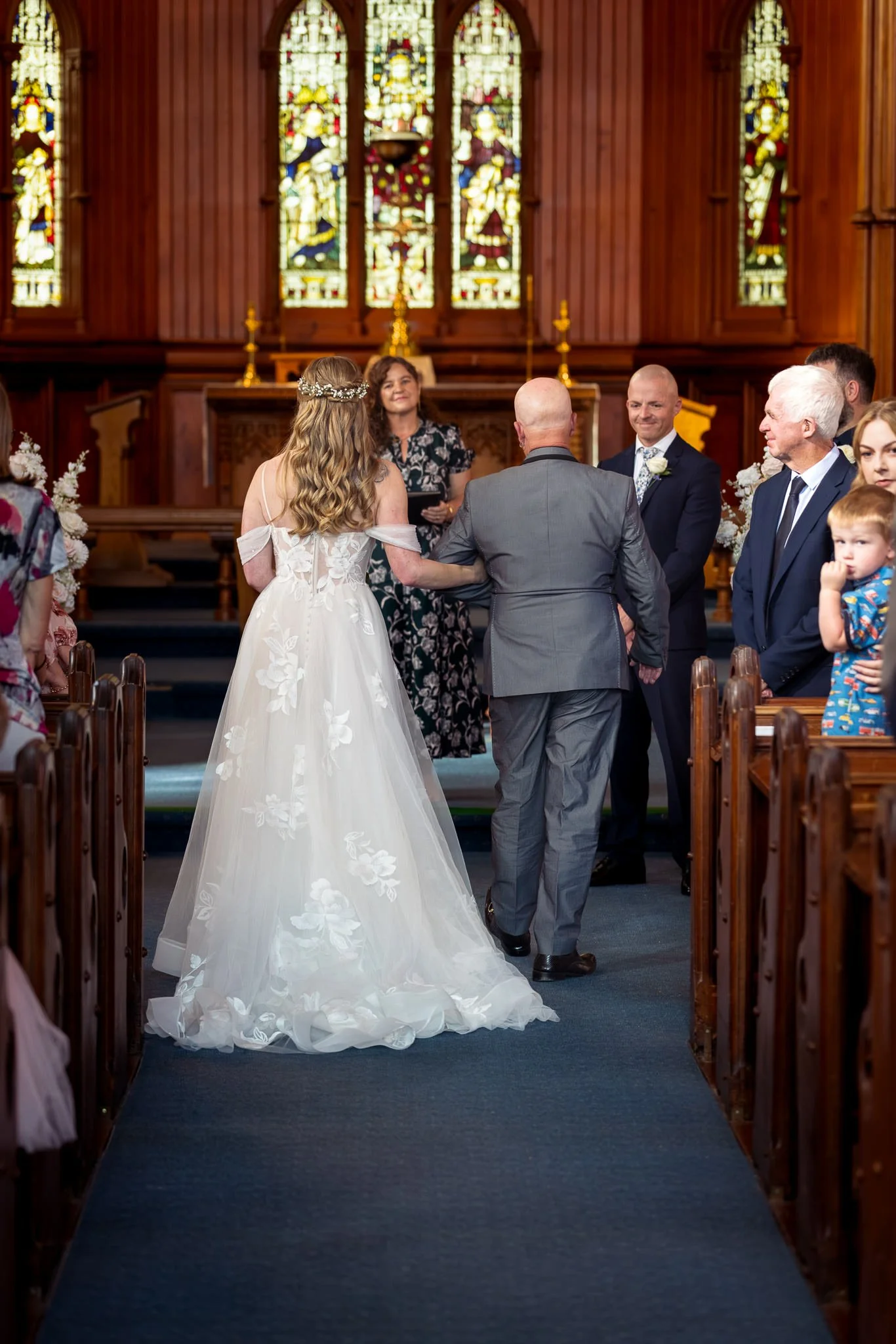 Kayla is walked down the aisle of Holy Trinity Church in Devonport