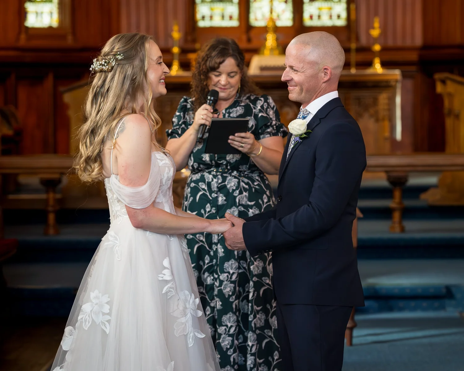 Kayla and Scott hold hands as the celebrant leads the ceremony