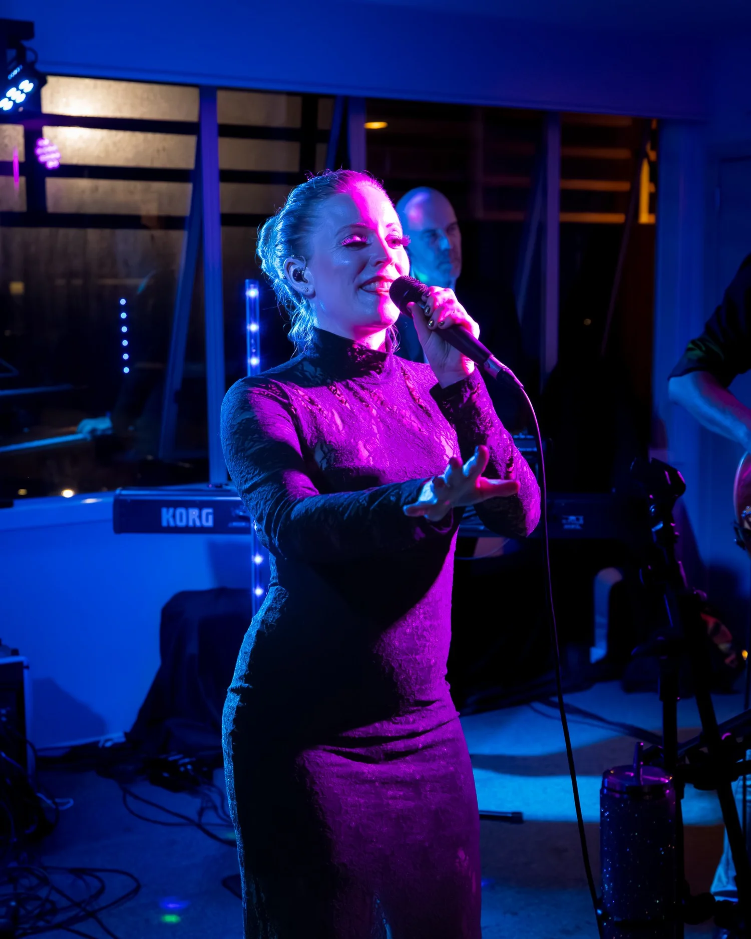 A singer performs under purple stage lights