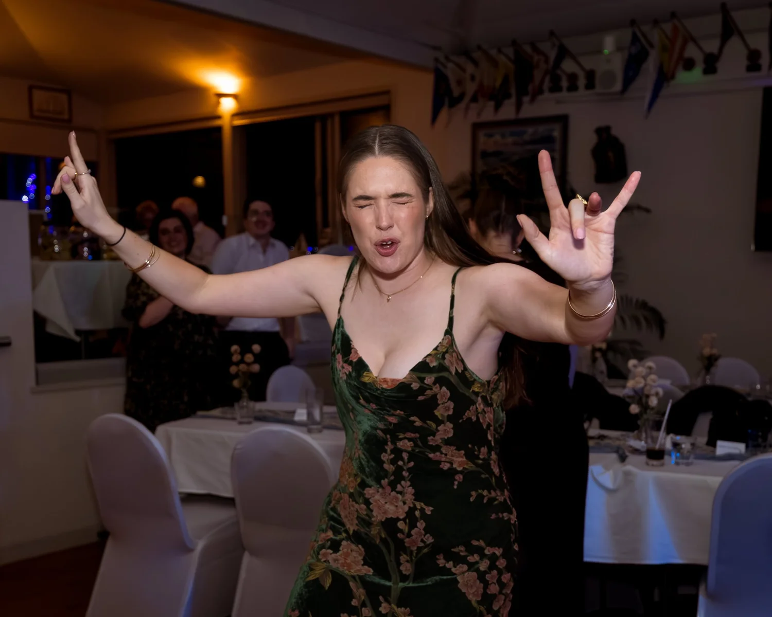 A guest dances with her arms in the air