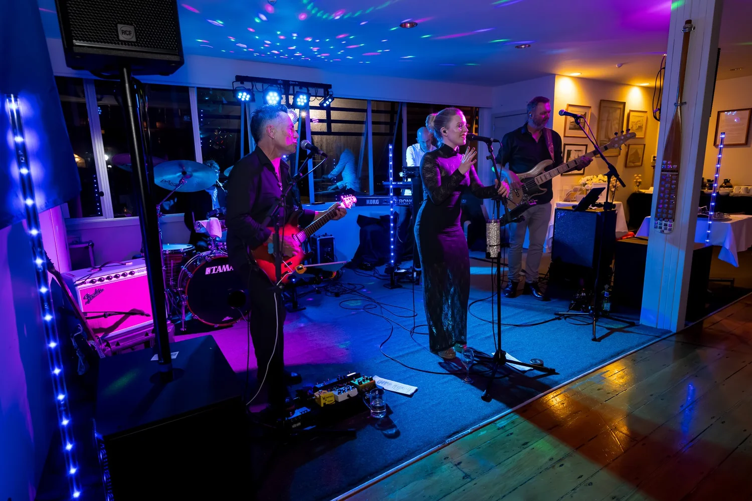 The band plays under blue and purple lights