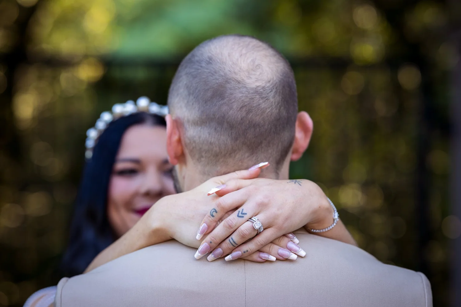 Emma hugs Corey from behind, her rings showing on his shoulder