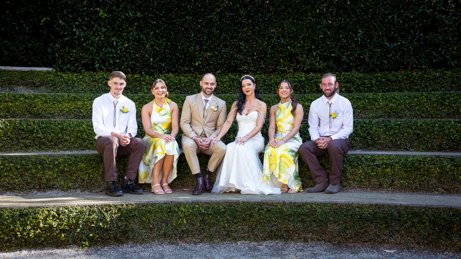 Emma and Corey with their bridal party on garden steps