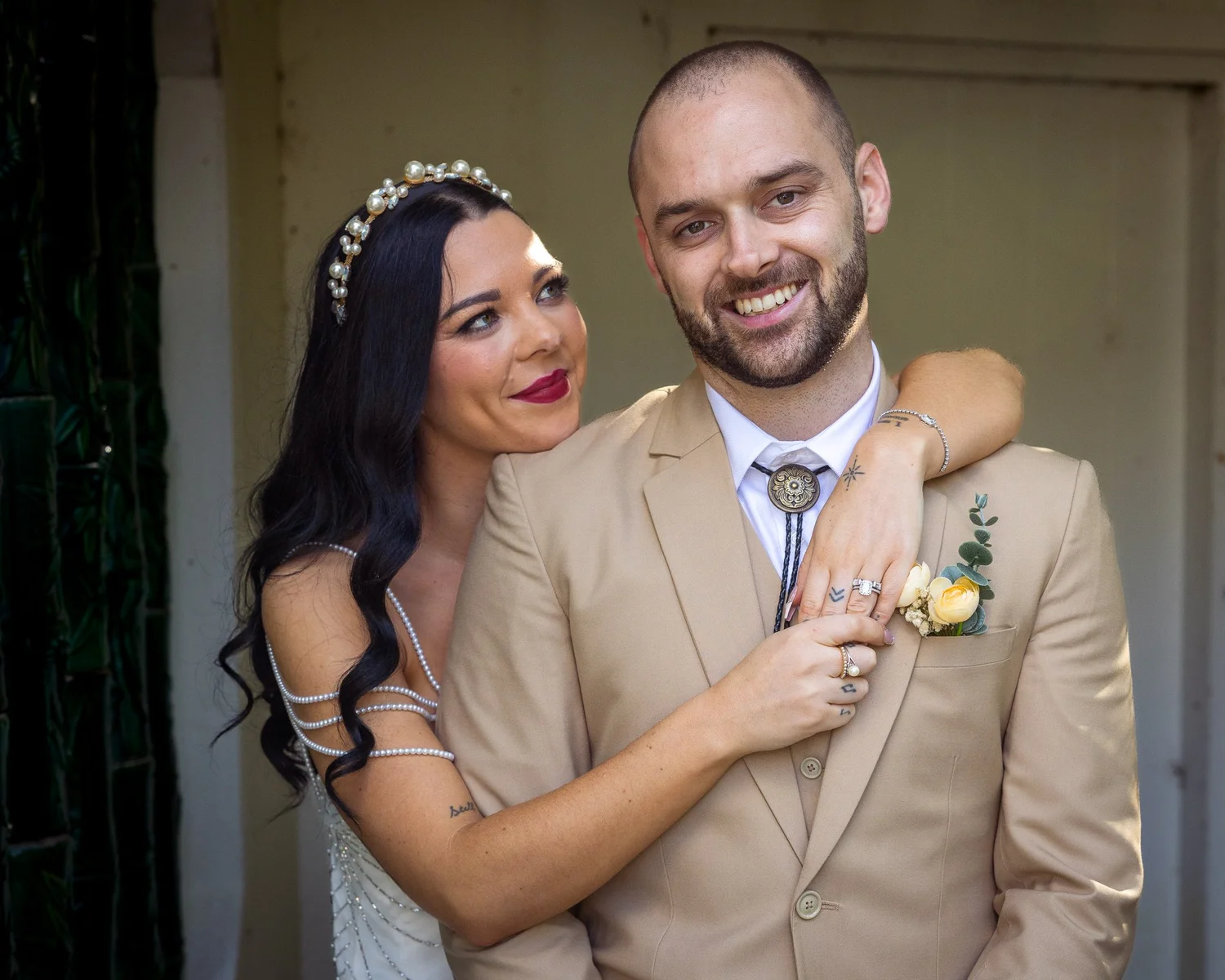 Emma wraps her arms around Corey as they smile at the camera