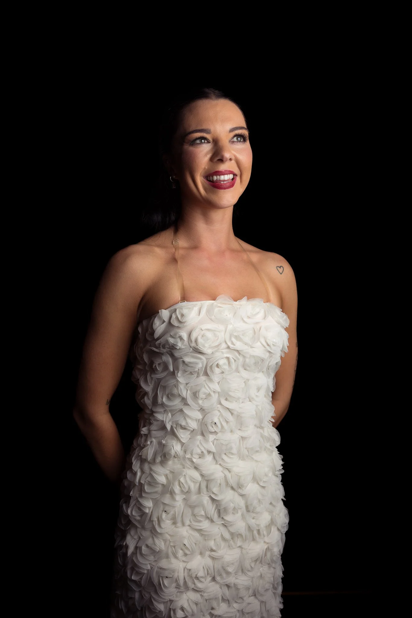 Emma smiles in her white flower-covered dress at the reception