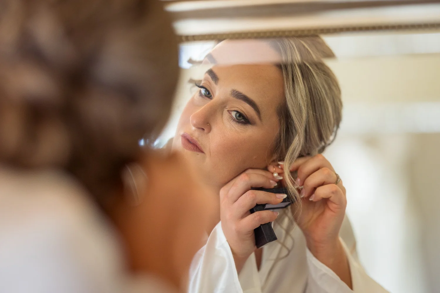Felicity puts in her earrings during preparations