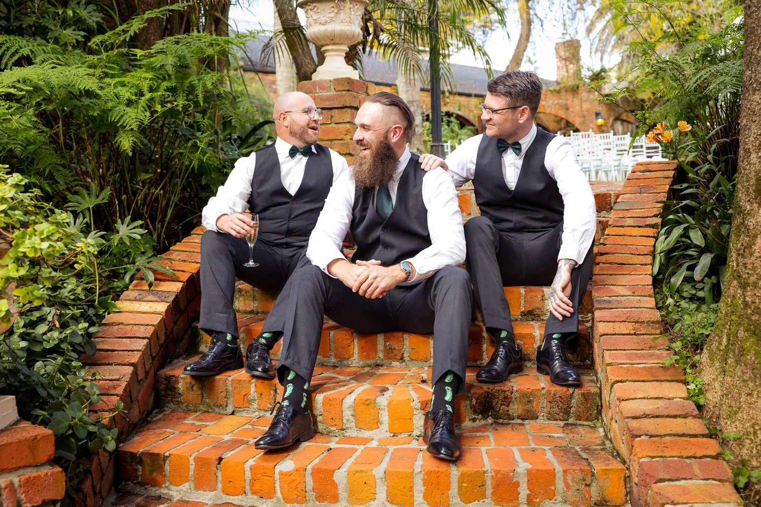 Ronan and his groomsmen sit on brick steps