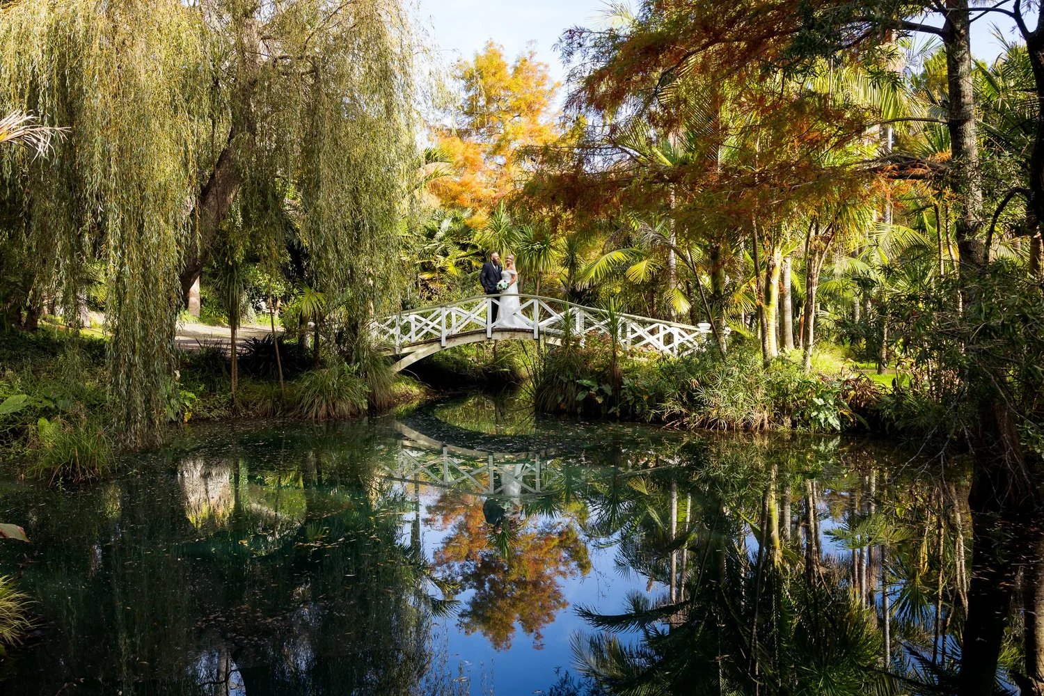 The pond and white bridge in the gardens at Settlers Country Manor