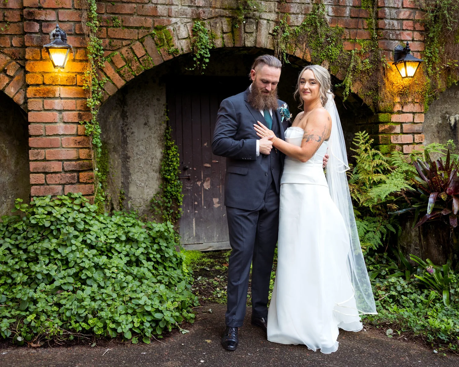 Felicity and Ronan beneath a brick archway with lanterns
