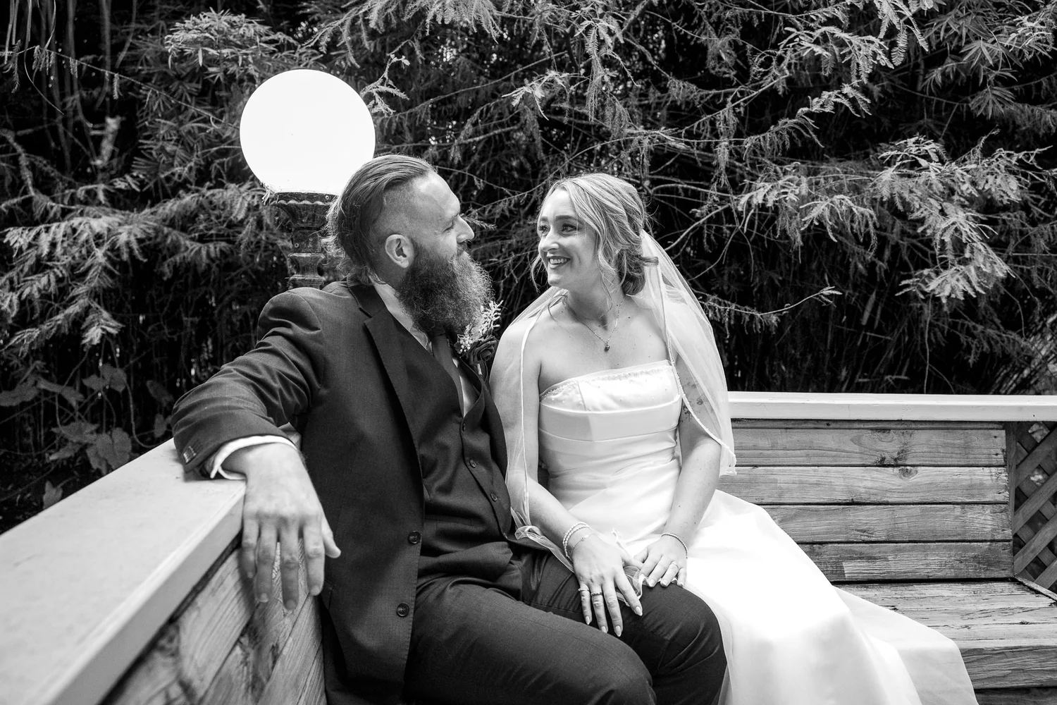 Black and white photo of Felicity and Ronan sitting together on a bench