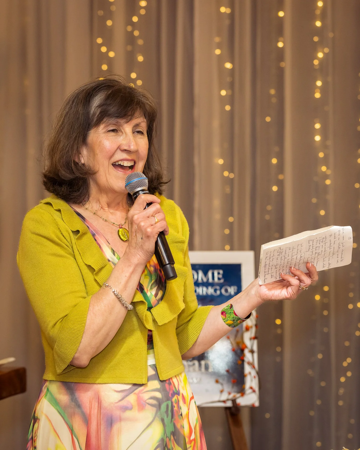 A guest in a yellow jacket reads her speech