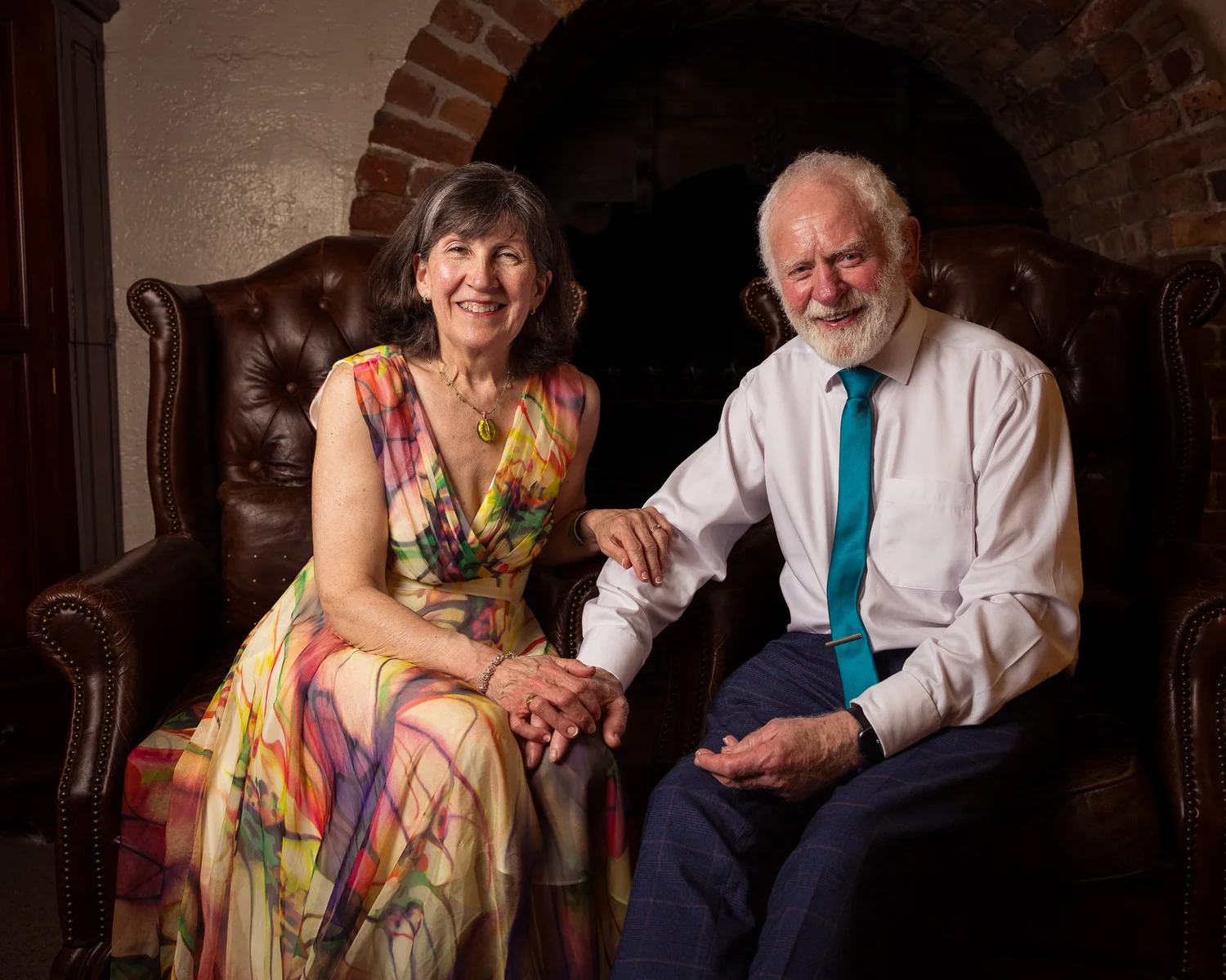 Two guests on a leather chesterfield for an evening portrait