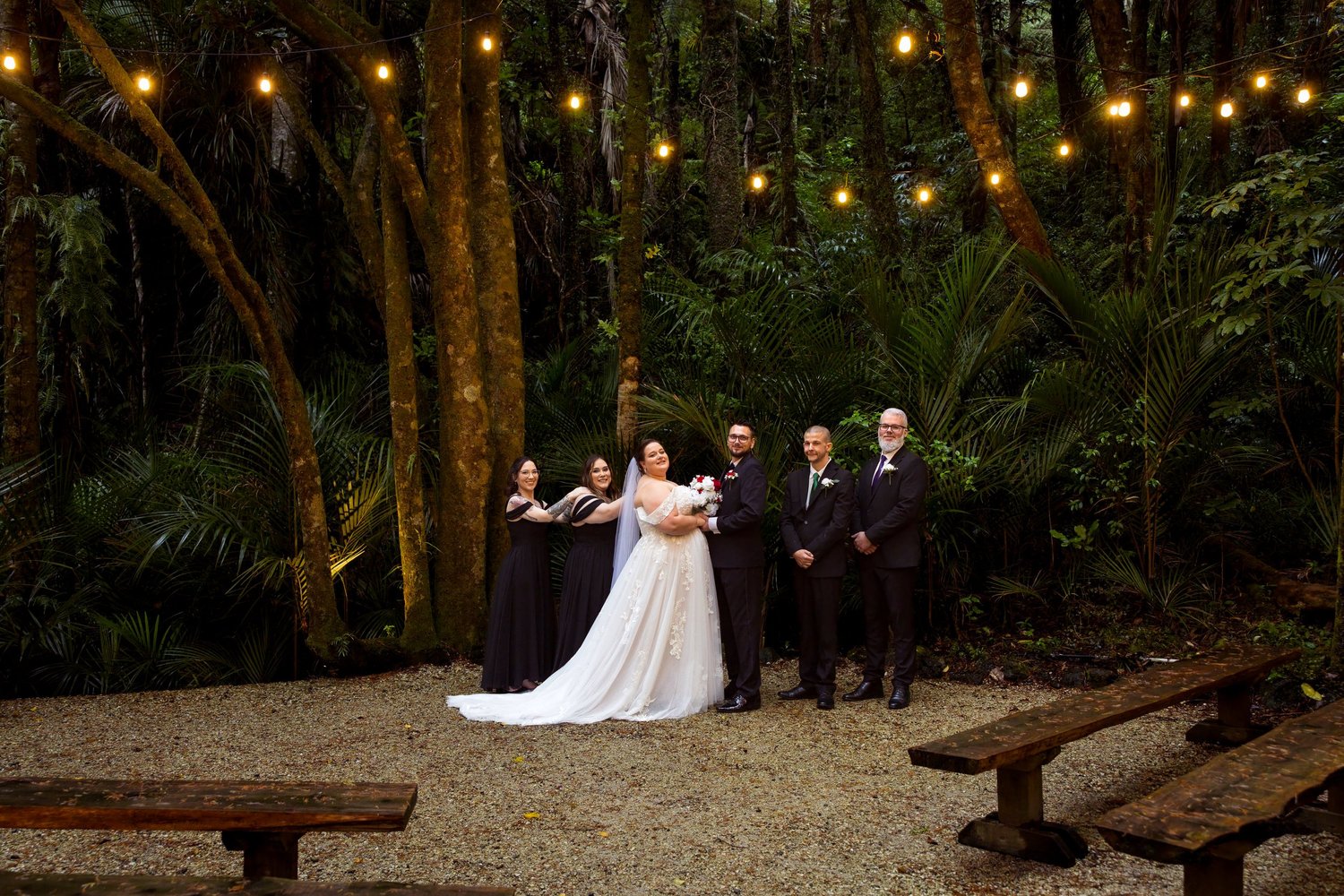 Rebecca and Nick with their bridal party under festoon lights