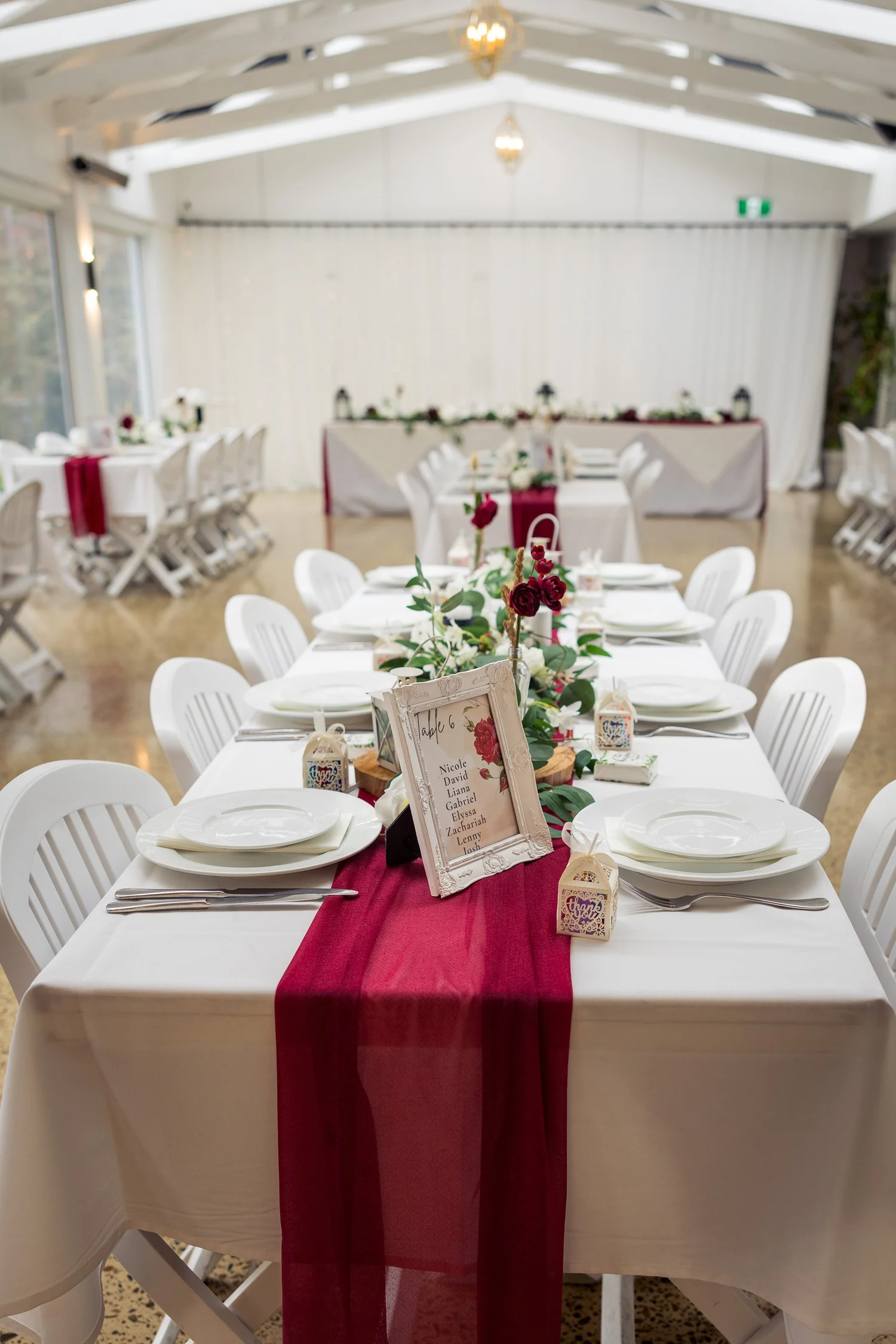 The reception table set with a burgundy runner