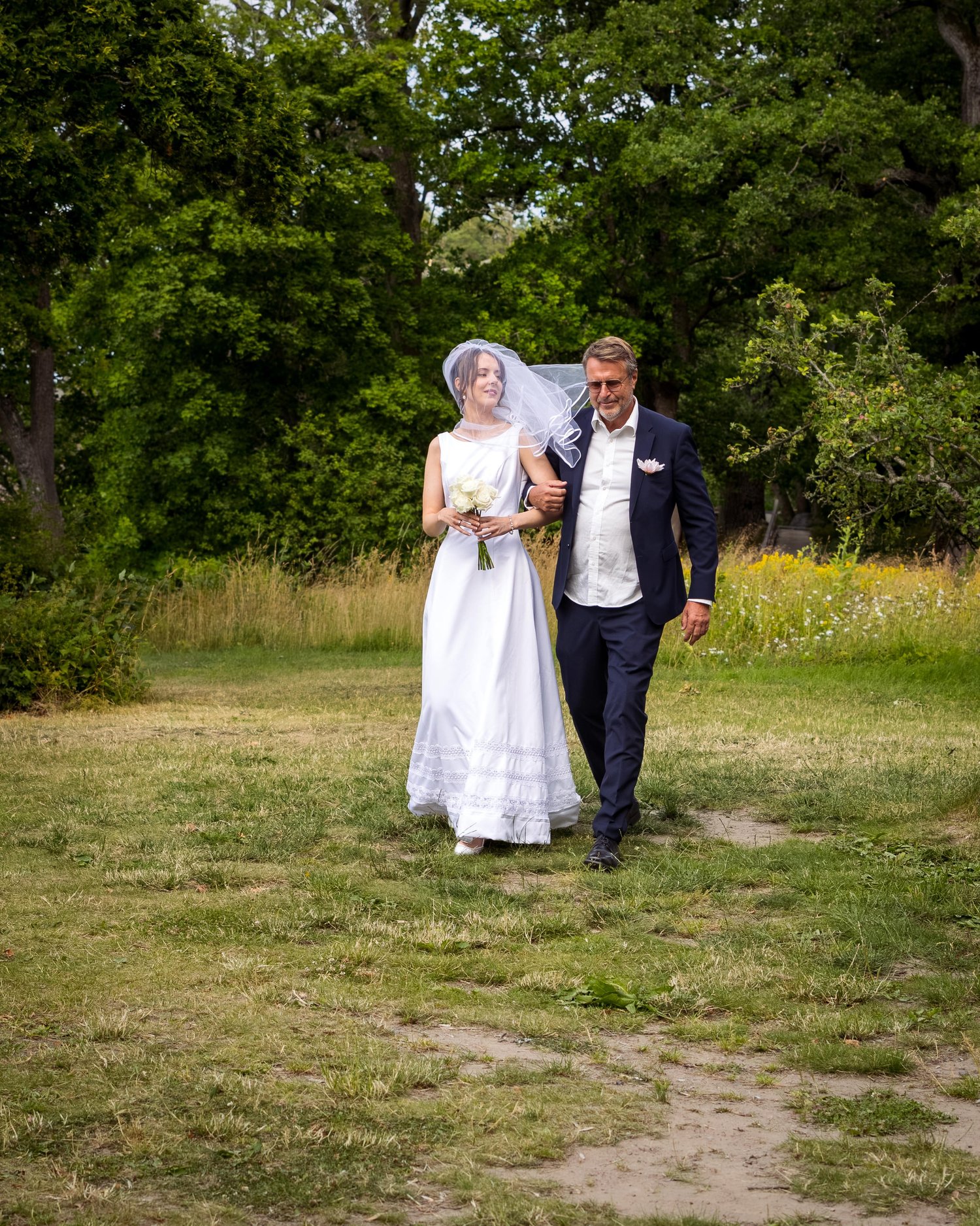 Sofia is walked across the meadow towards the ceremony