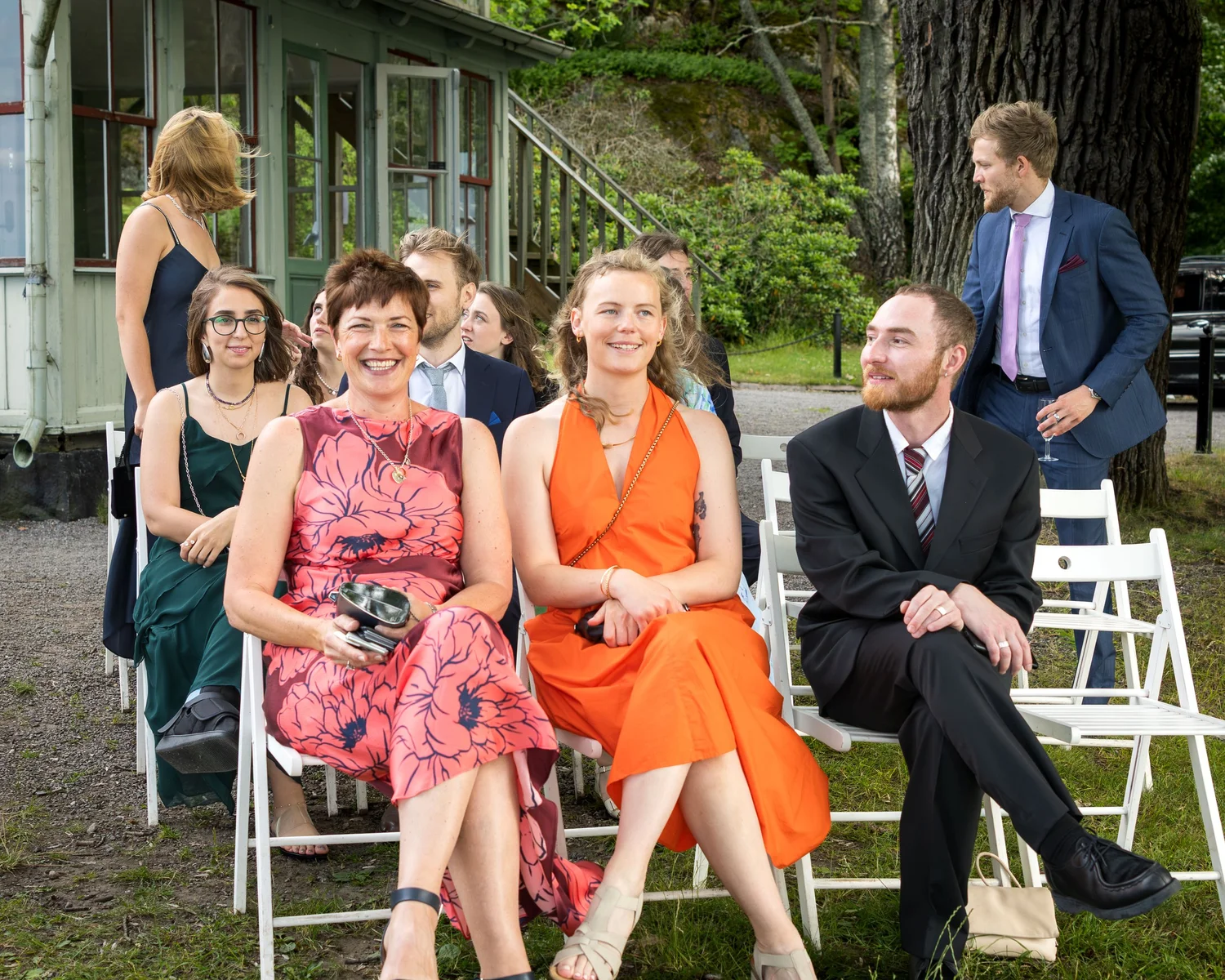 Guests seated on white chairs await the ceremony