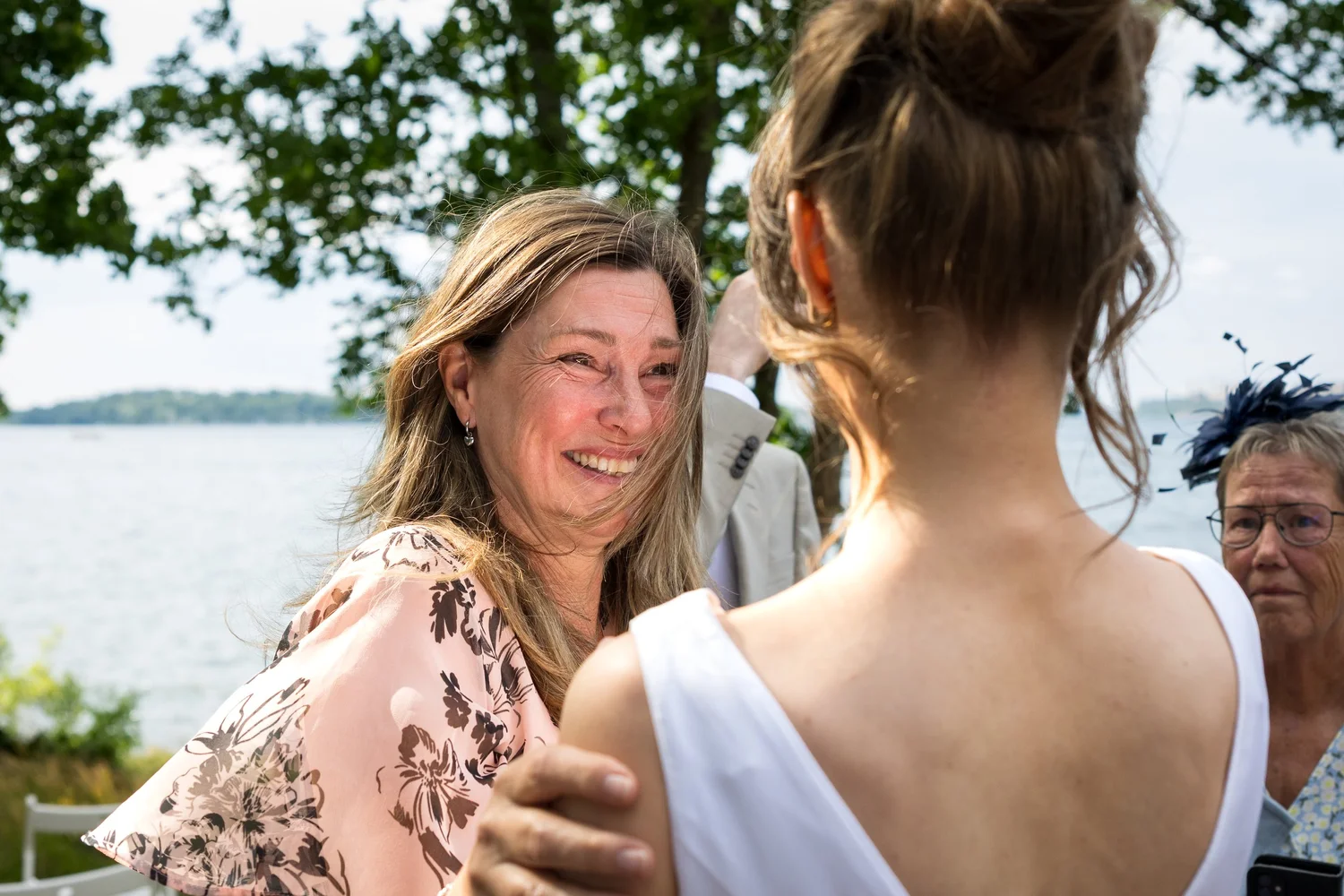 A guest smiles tearfully at Sofia by the water