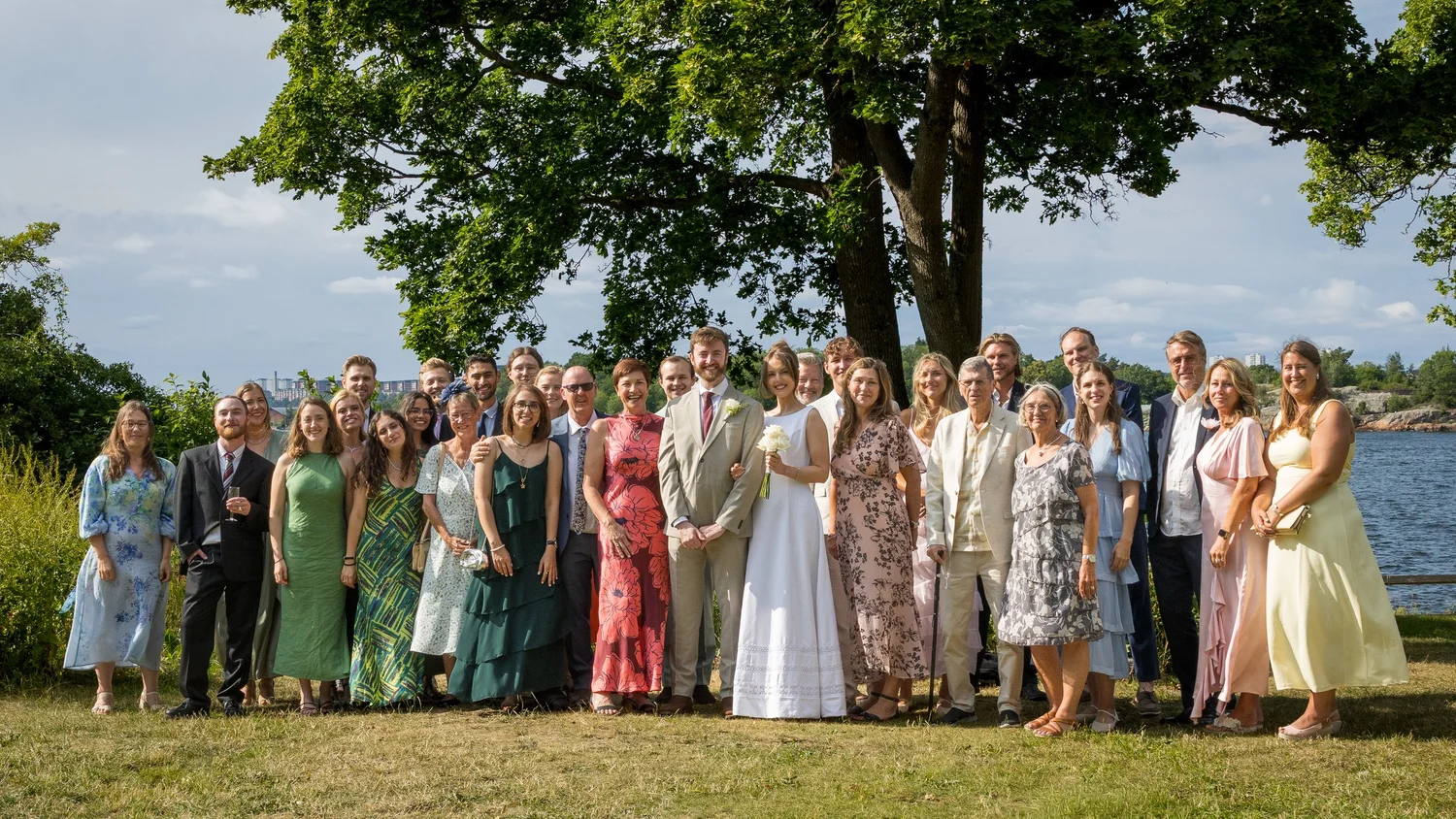 Sofia and John with all their guests by the water