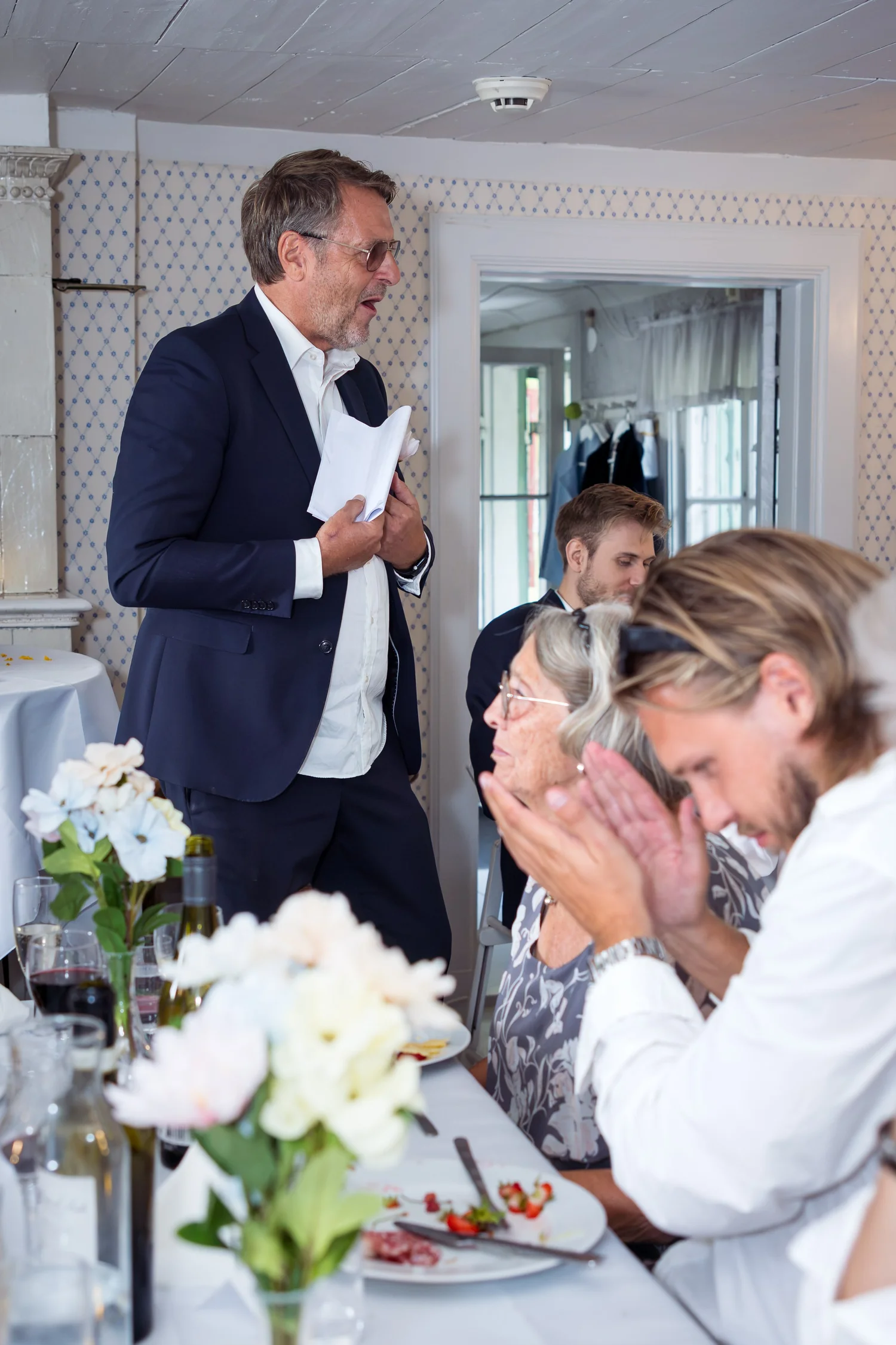 A guest speaks as others laugh at the table
