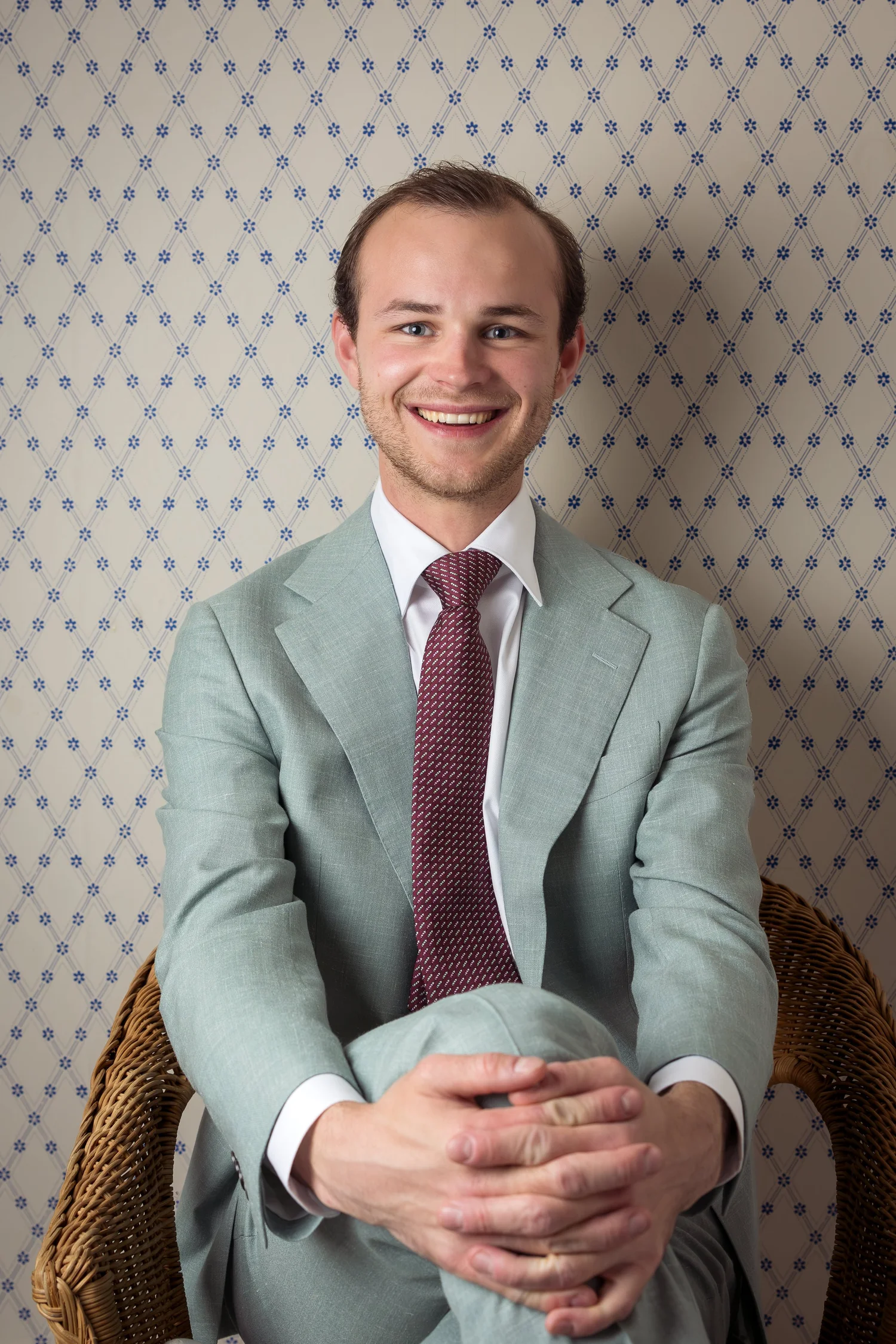 A guest in a sage suit seated for a portrait
