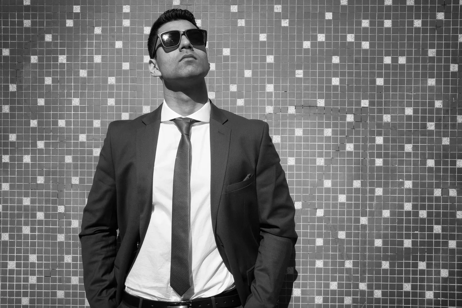 Black and white portrait of a man in a suit and sunglasses