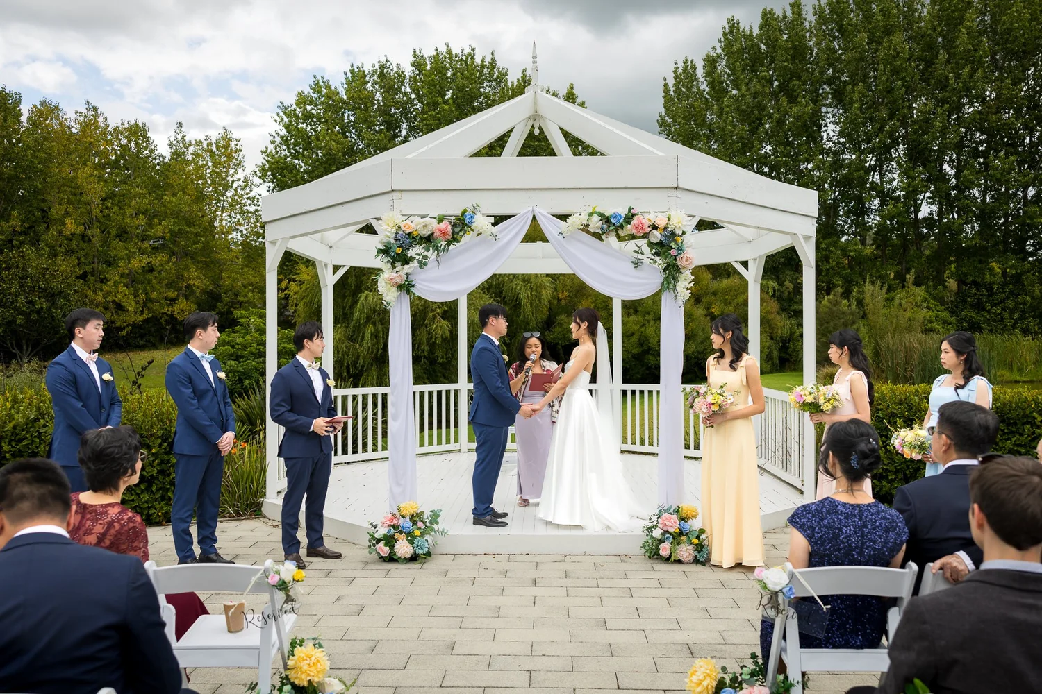 A couple exchange vows at the white gazebo
