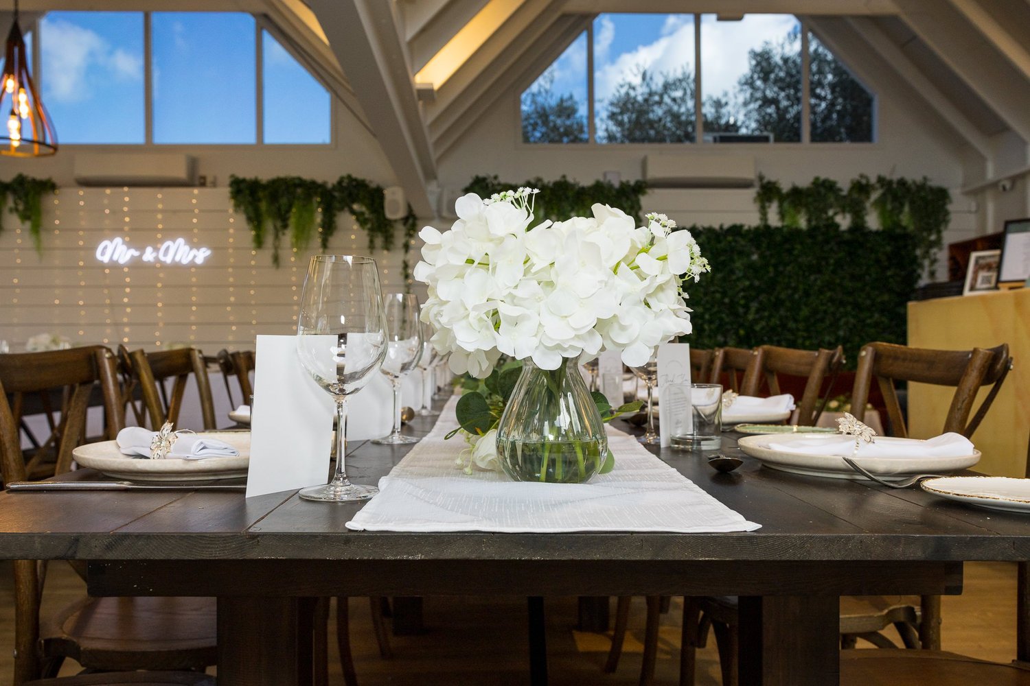A reception table set with white flowers and candles at Abel Estate