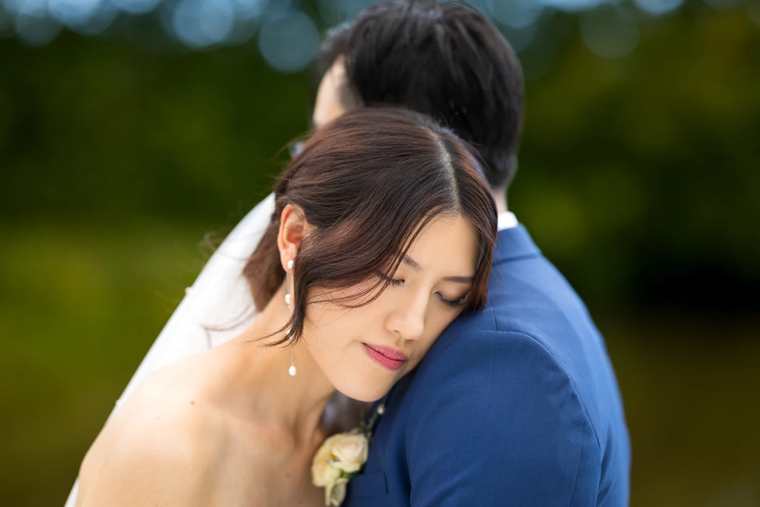 A bride rests her head on her groom's shoulder