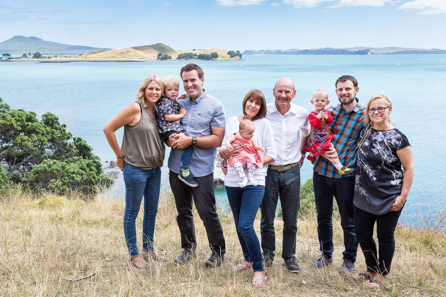 A family stands on a clifftop above the sea