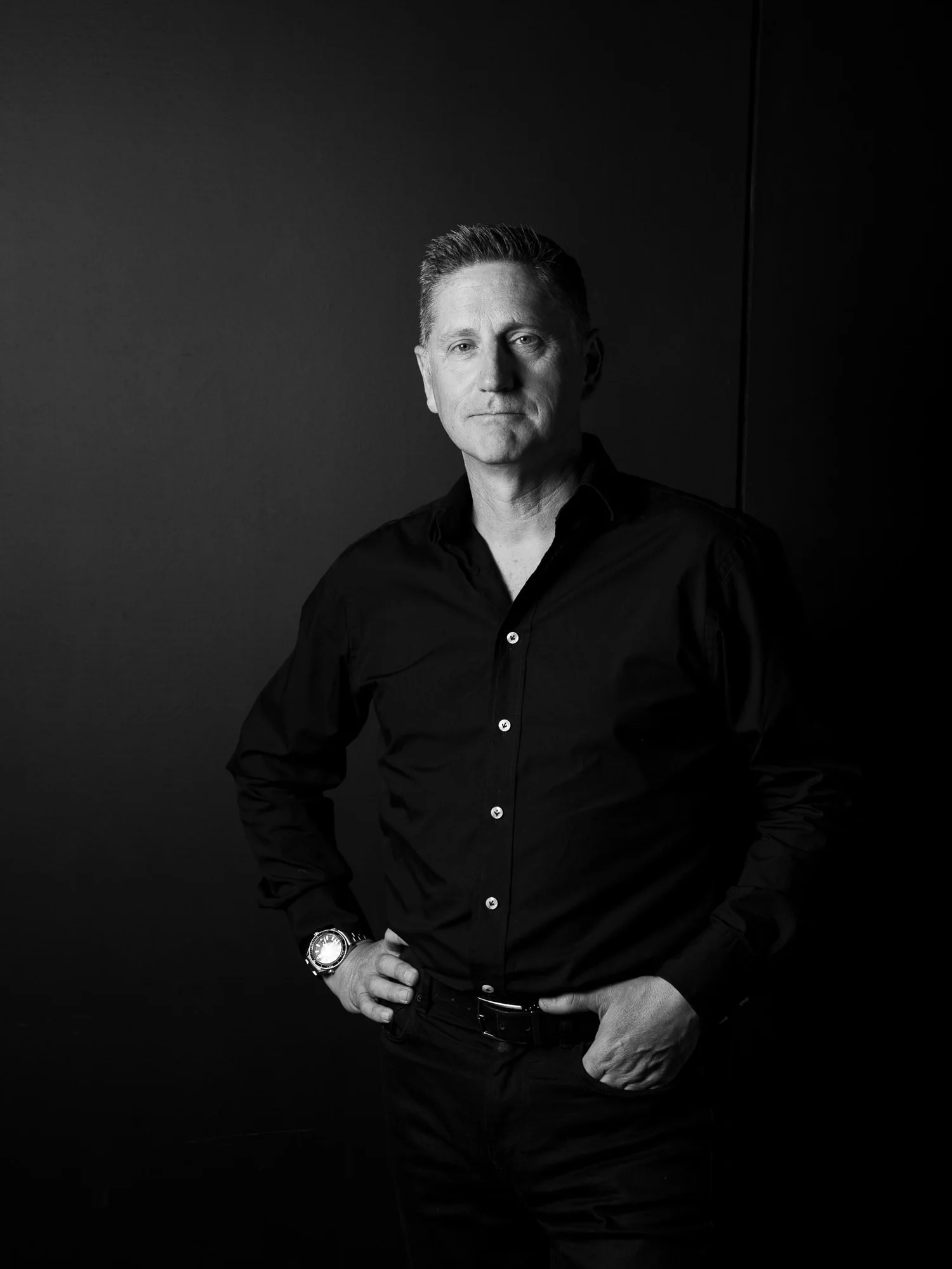 Black and white business headshot of a man in a dark shirt