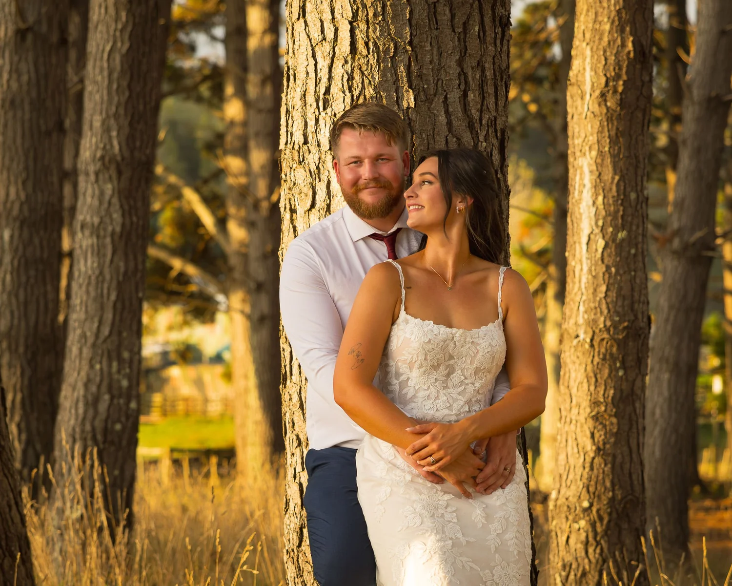 Wedding couple among the trees at golden hour