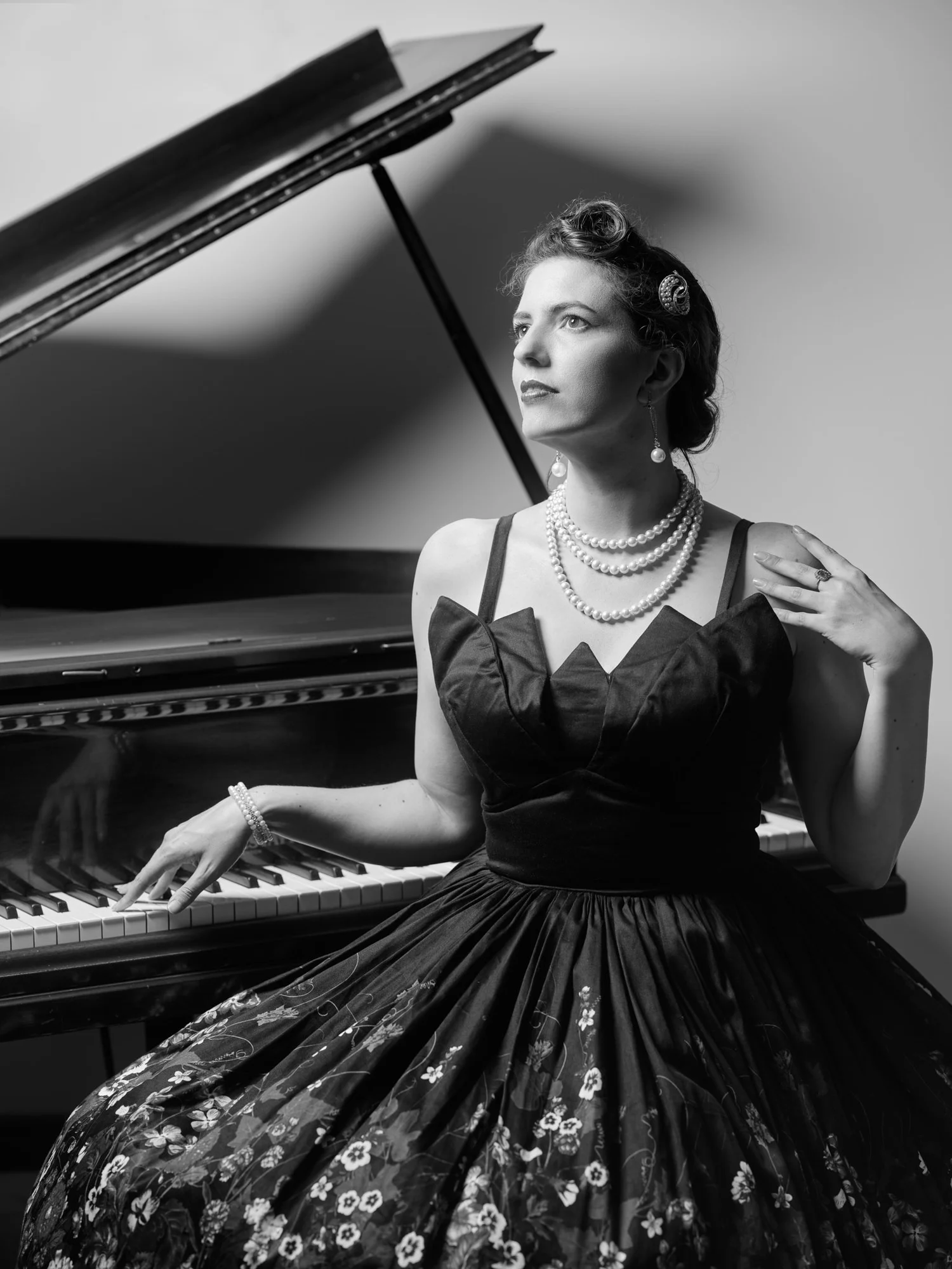 Black and white photo of Jay seated at a grand piano