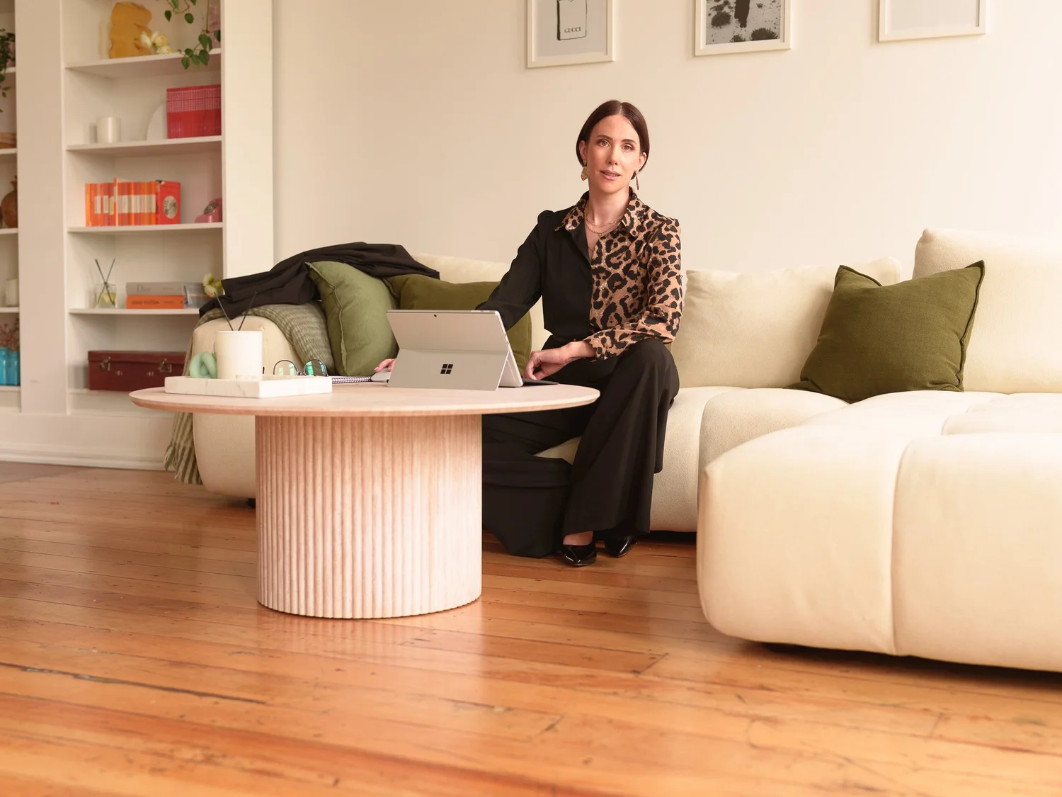A woman seated in a lounge beside a fluted coffee table
