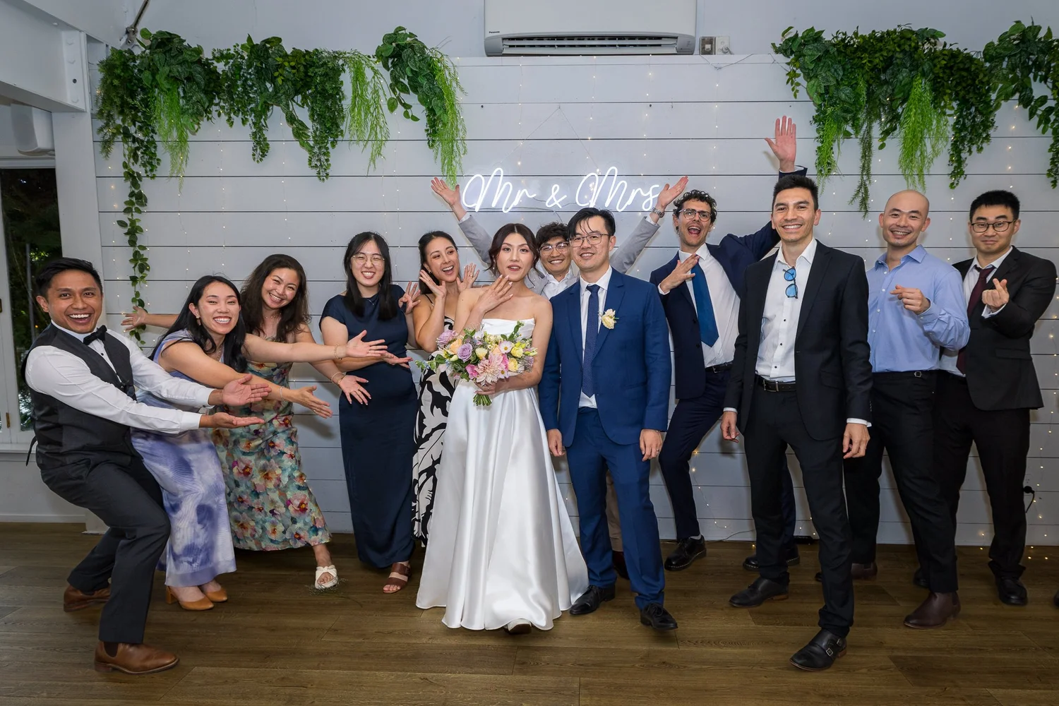 A bridal party strikes a playful pose in the reception room