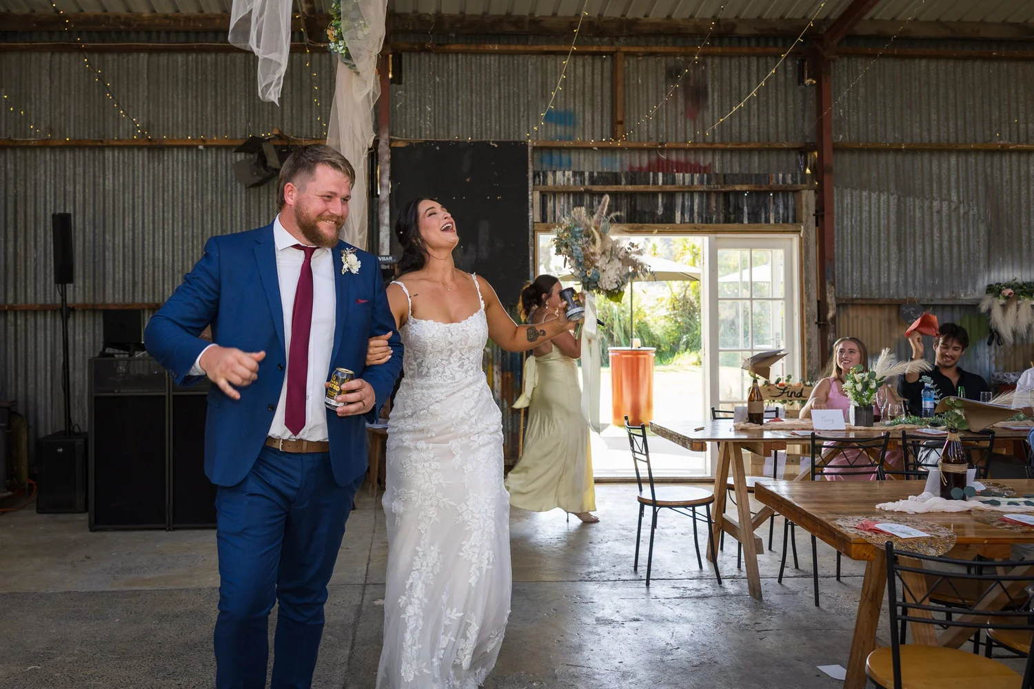 A couple laugh as they walk through the reception