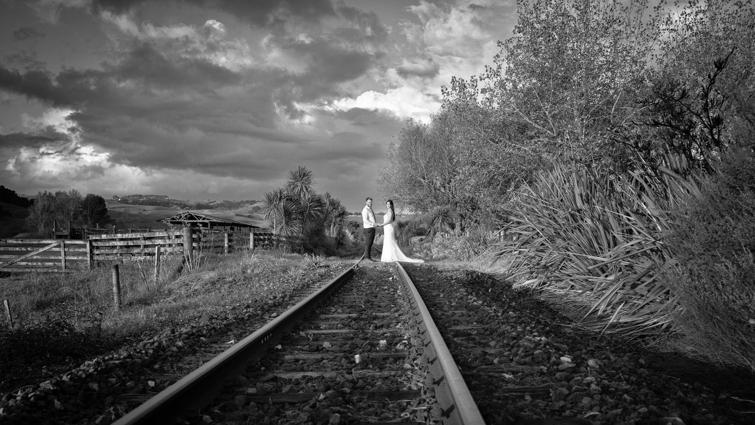 Black and white photo of a bride on a railway line