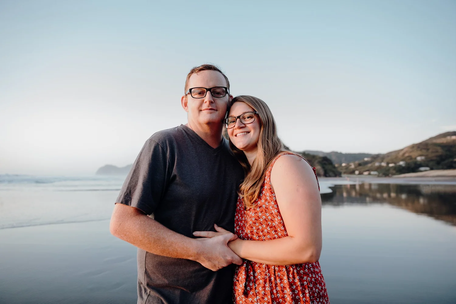 A couple embrace on the beach at sunset