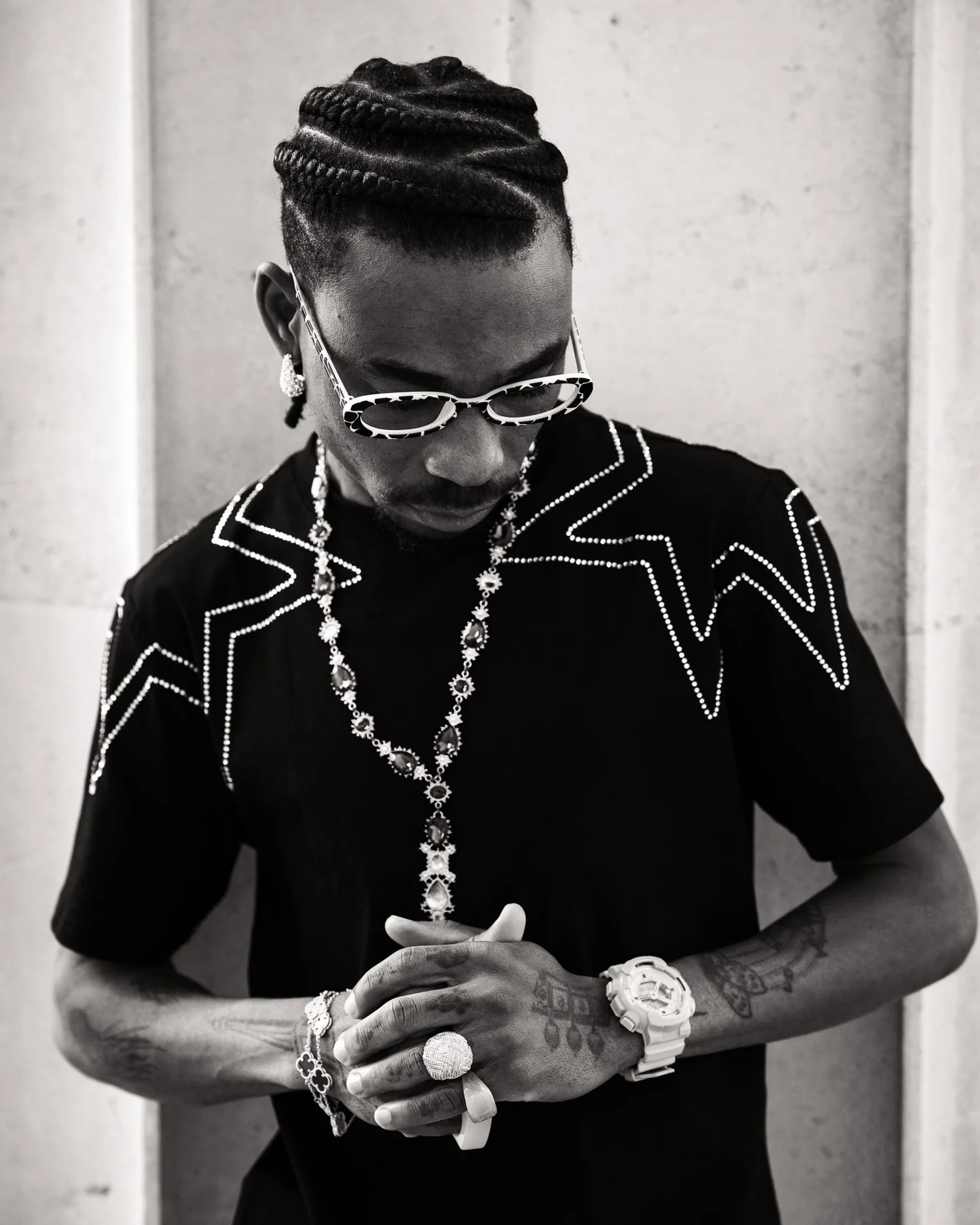Black and white photo of a man in a studded shirt and chains